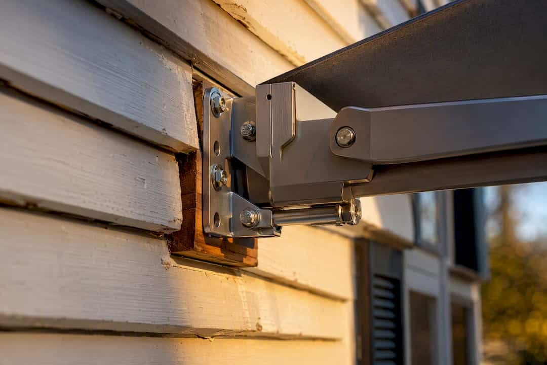 Awning mounting bracket anchored to wall
